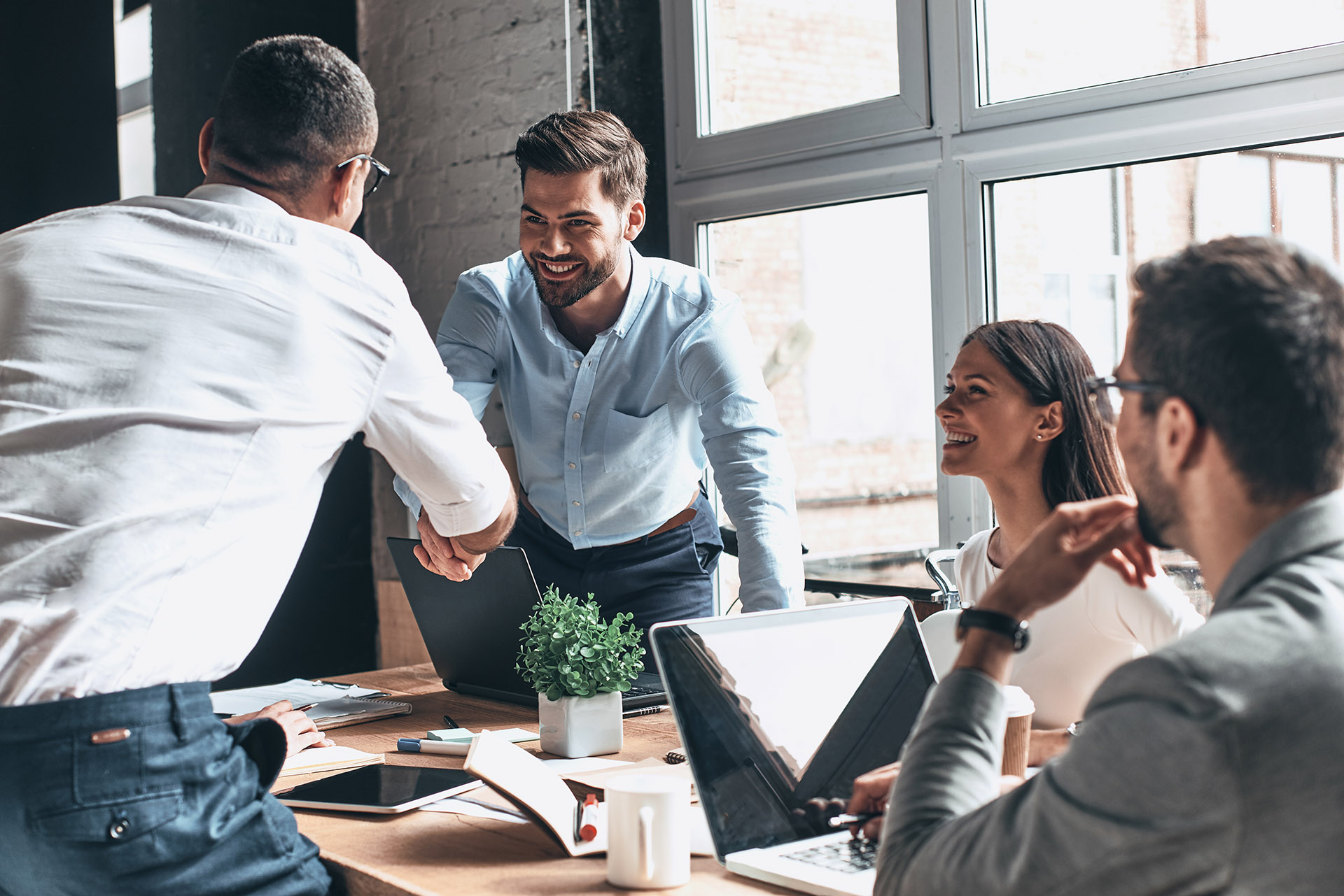 Business people meeting in industrial chic office shaking hands