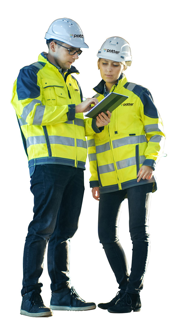 male and female Potter engineers wearing yellow safety jackets and hardhats on job site viewing tablet